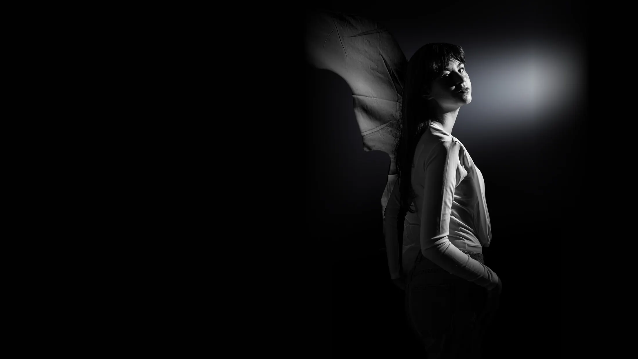 Retrato en blanco y negro con luz lateral sobre fondo negro