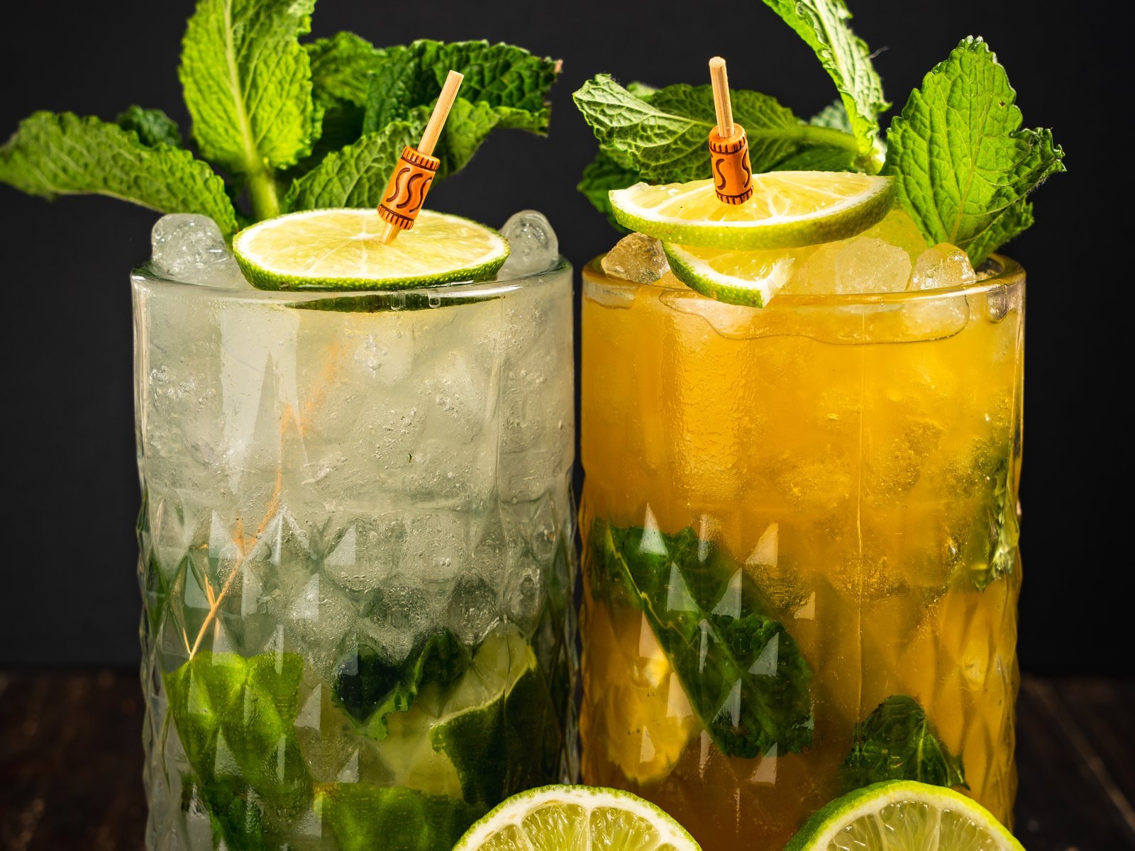Dos mojitos con lima y hierbabuena sobre fondo oscuro, fotografía de cócteles para un chiringuito